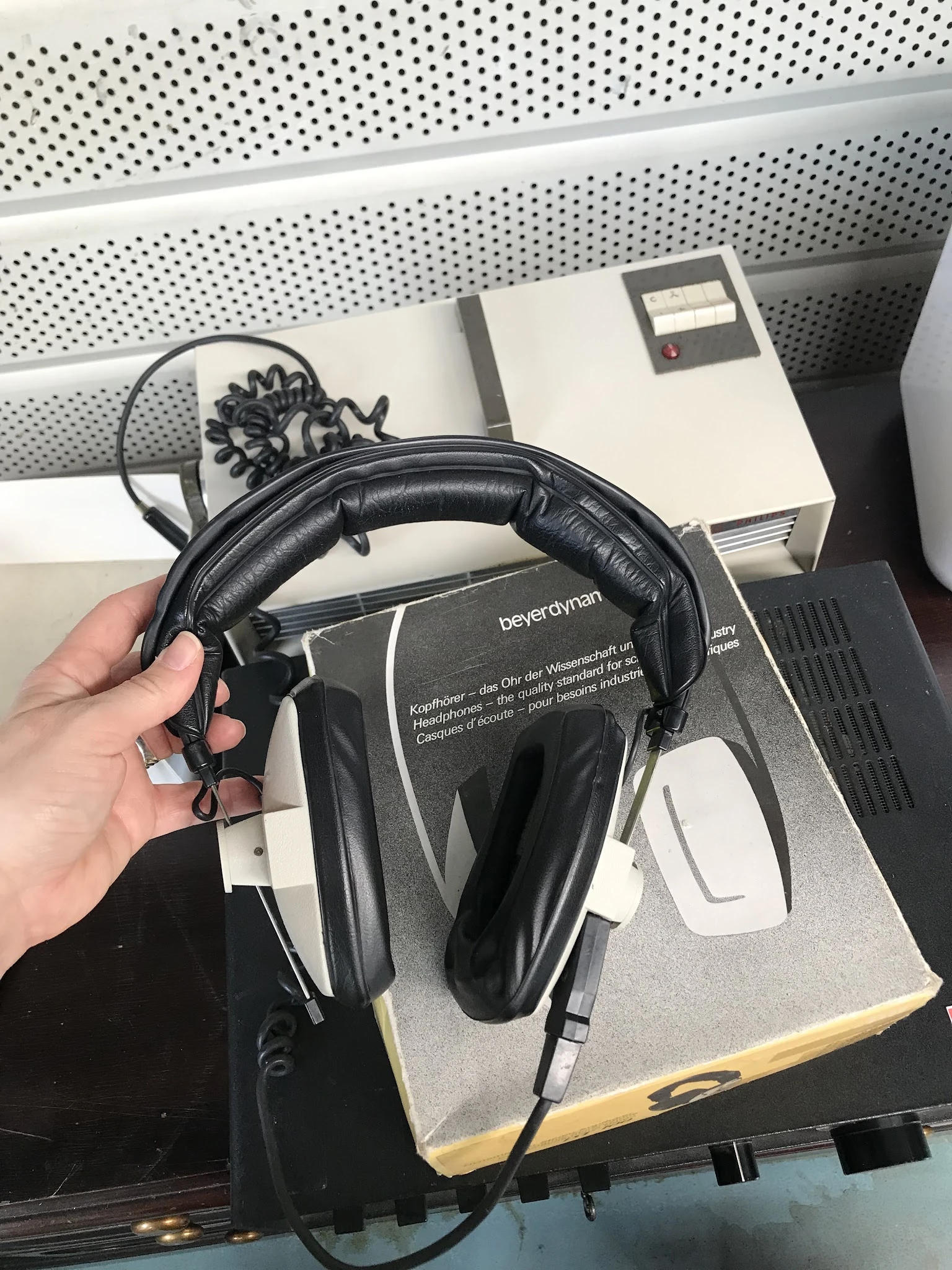 Zwarte over-ear koptelefoon met kabelaansluiting in hand gehouden