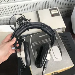 Zwarte over-ear koptelefoon met kabelaansluiting in hand gehouden