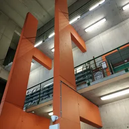 Interieur van kringloopwinkel met oranje stalen zuilen, galerijverdiepingen en fluorescente verlichting