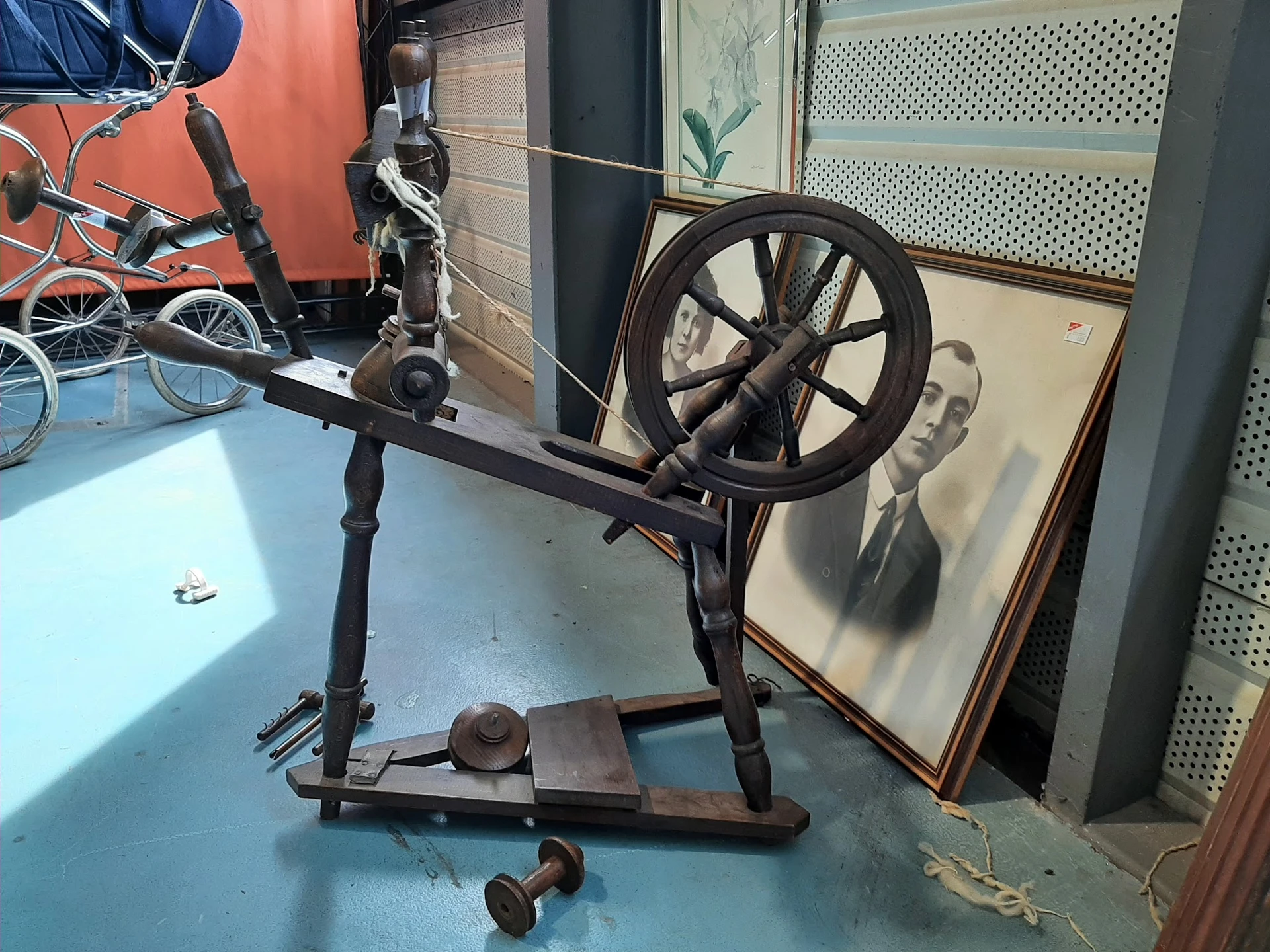 Antieke spinnewiel op standaard, zwart metaal, in een kringloopwinkel