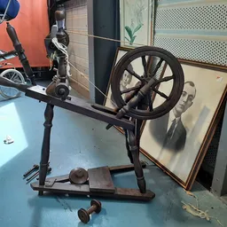 Antieke spinnewiel op standaard, zwart metaal, in een kringloopwinkel