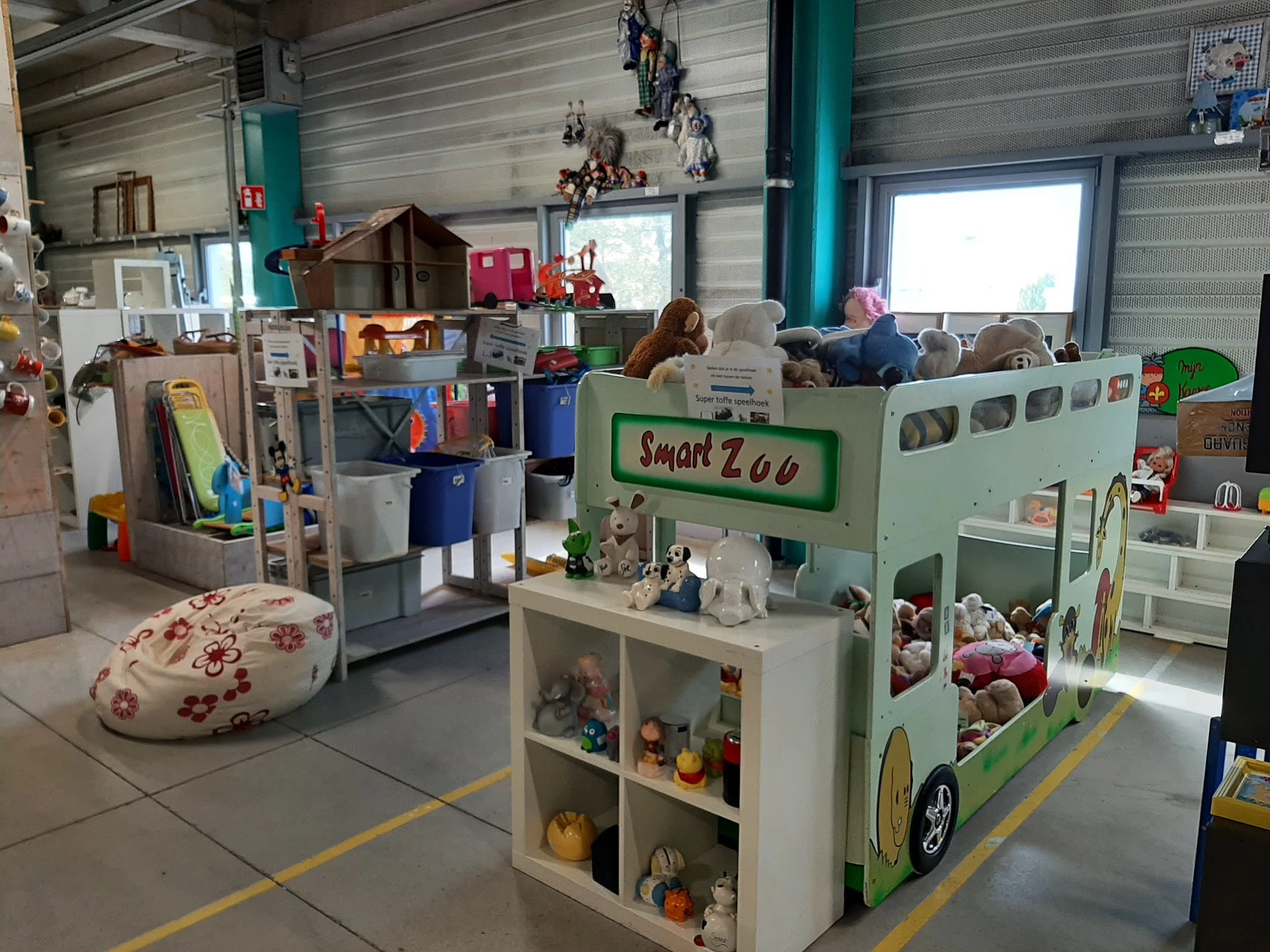 Winkelinterieur met speelgoedhuisjes, knuffels en kinderspeelgoed op de winkelruimte