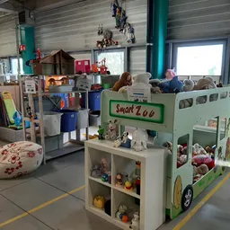 Winkelinterieur met speelgoedhuisjes, knuffels en kinderspeelgoed op de winkelruimte