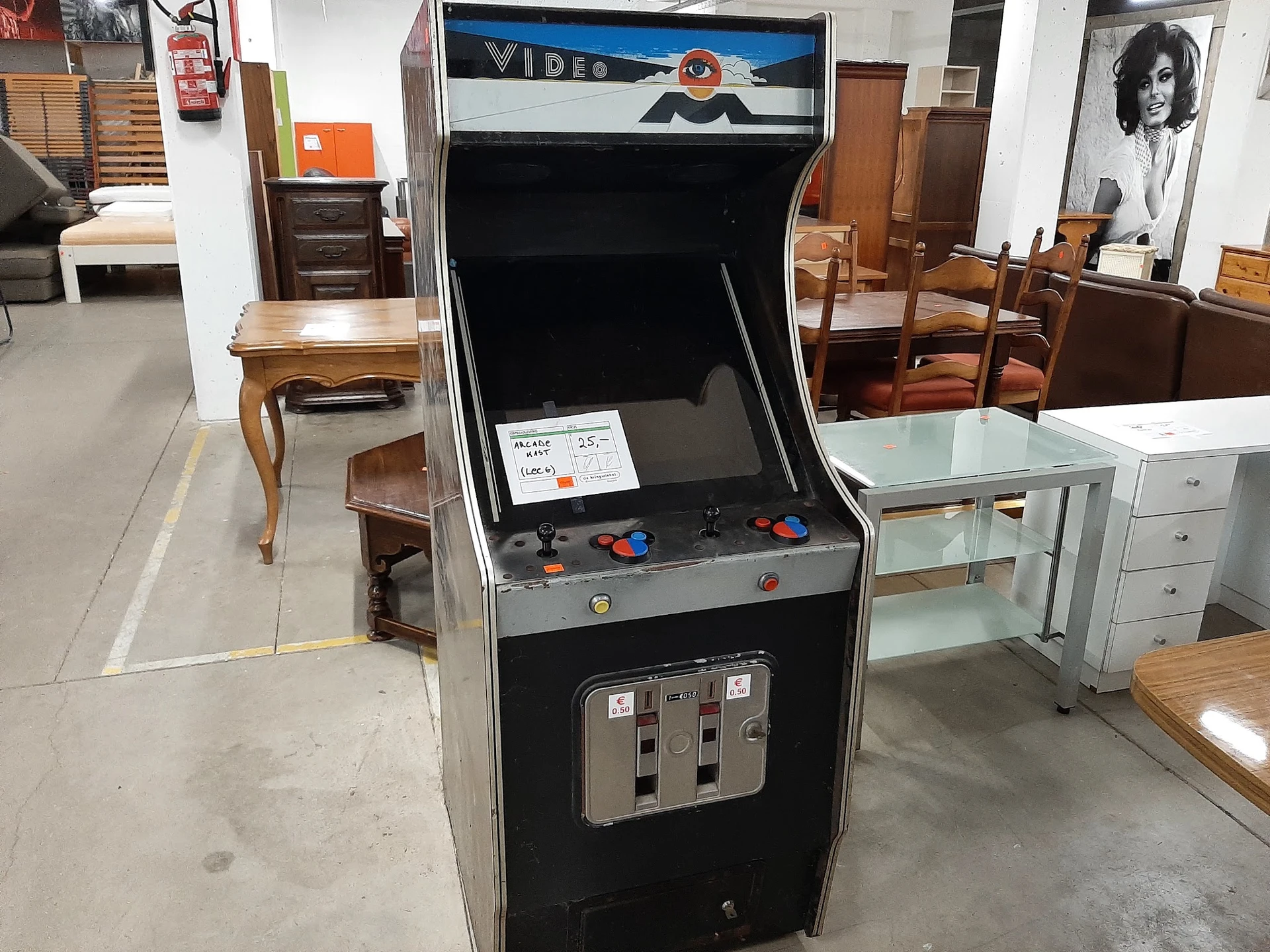 Vintage Video arcade-automaat met zwart-grijs design en rode joystick-knoppen in kringloopwinkel