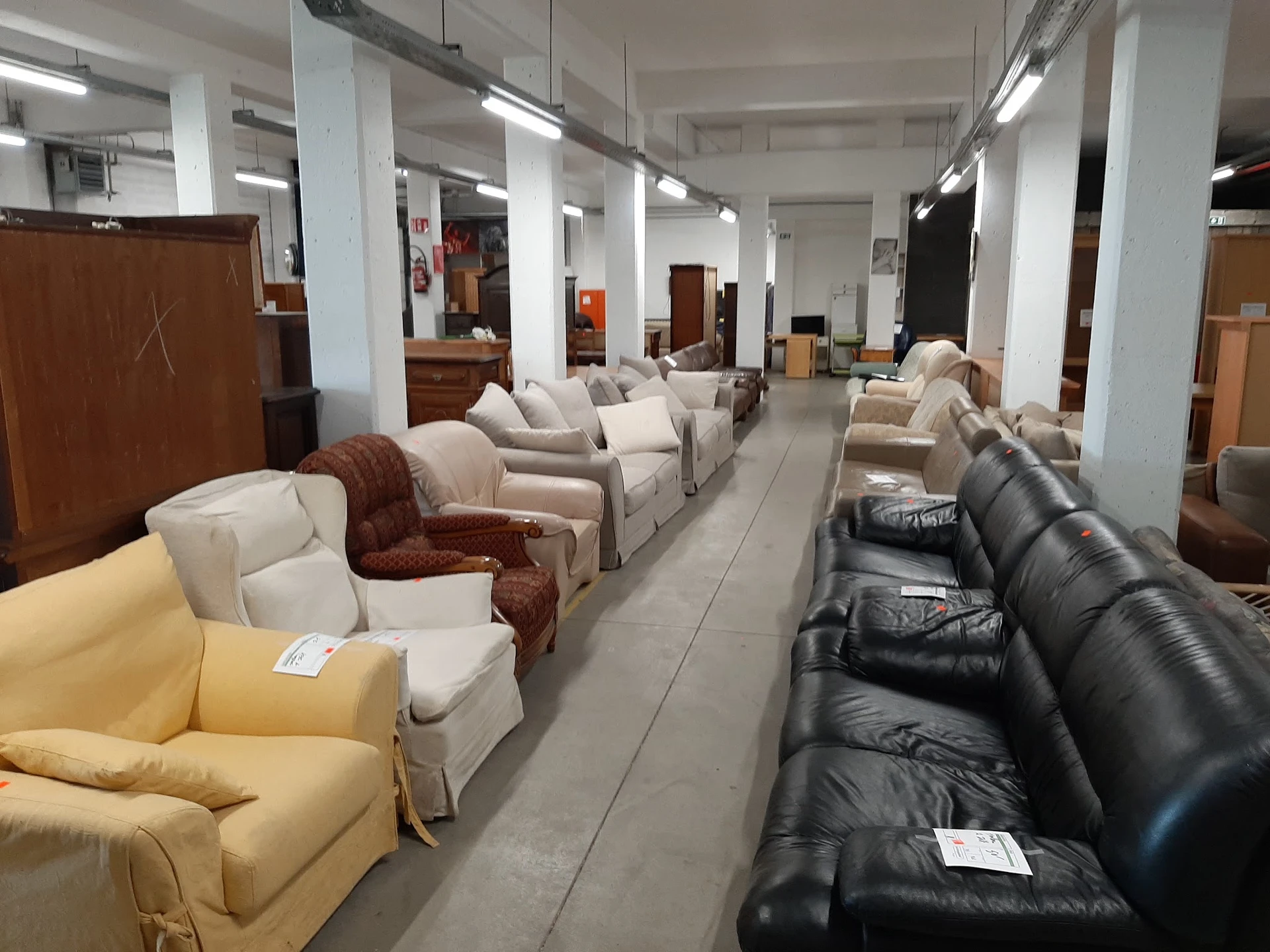 Winkelvloer met uitgestalde meubels: stoelen, banken en fauteuils in verschillende kleuren