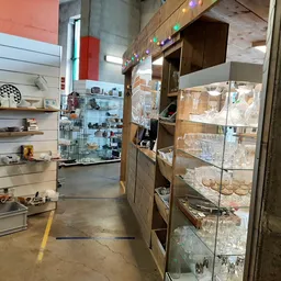 Winkelvloer met stellingen en vitrines vol tweedehandsartikelen in kringloopwinkel