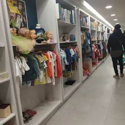 Rekken met kinderkledingaanbod in verschillende kleuren en maten in de kringloopwinkel
