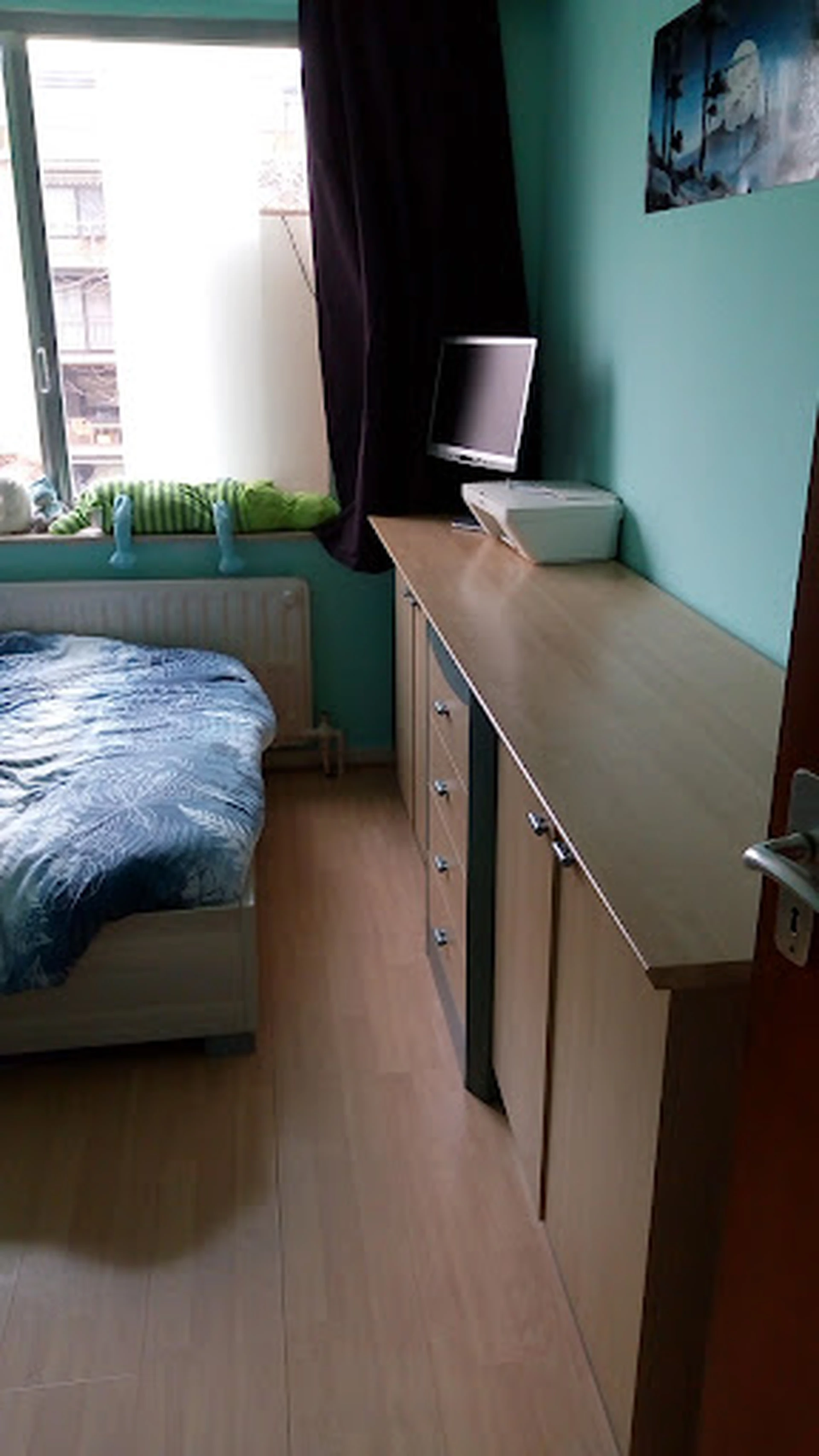 Tweedehands houten dressoir met blauwe bedsprei zichtbaar op achtergrond