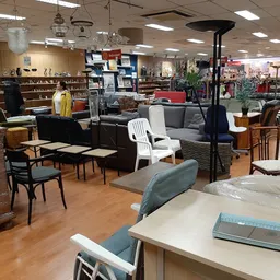 Winkelvloer met meubels, stoelen, tafels en diverse spullen uitgestald in een kringloopwinkel