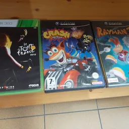Drie tweedehands videogames op houten plank: Xbox 360 Tour de France, GameCube Crash Tag Team Racing en GameCube Rayman 2
