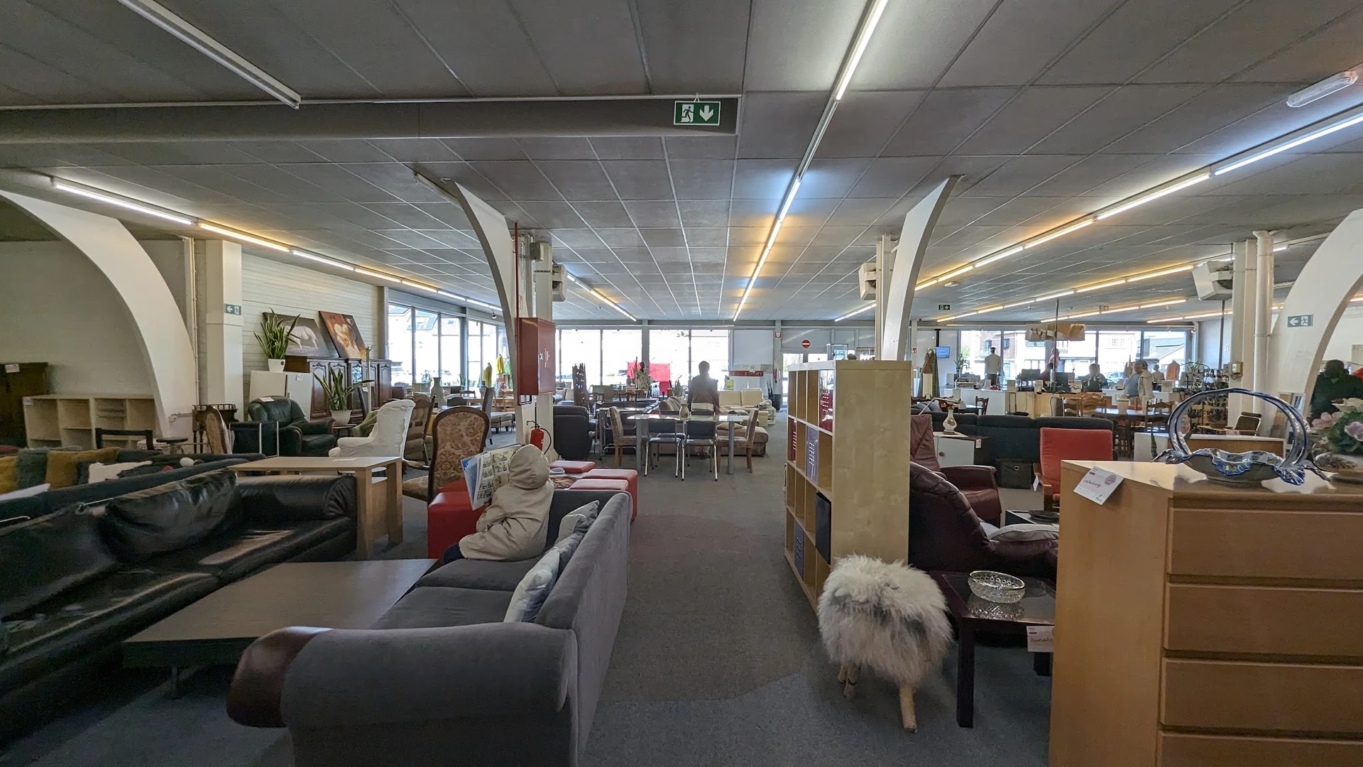 Ruime winkelvloer met meubels, boekenkasten en diverse tweedehands artikelen uitgestald