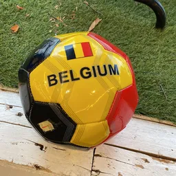 Gele voetbal met Belgische vlag en opschrift 'BELGIUM' op houten oppervlak