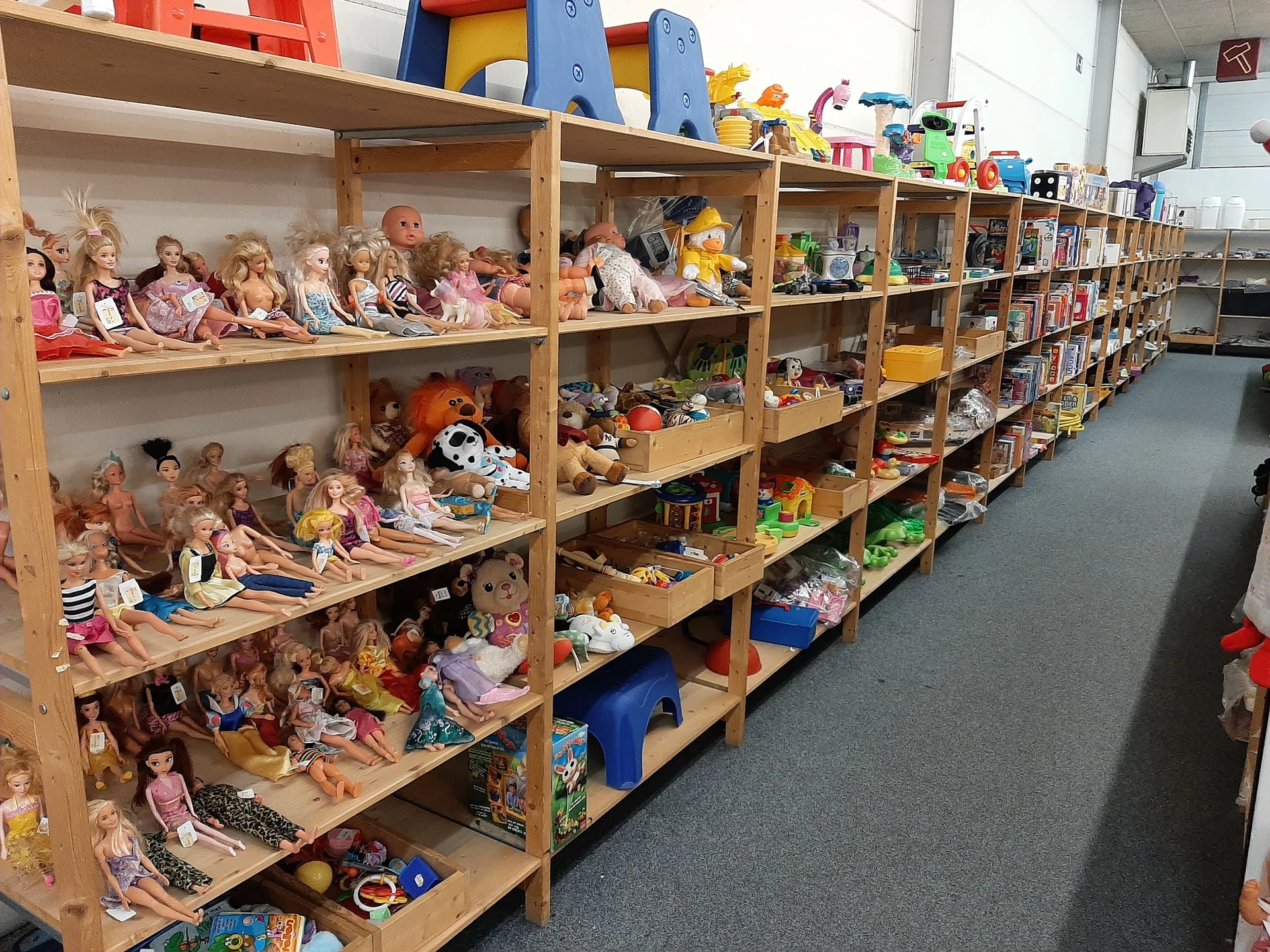 Houten stellingen vol met poppen, speelgoed en verschillende kinderspeelgoed articles