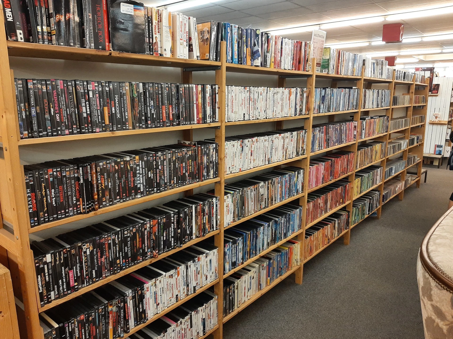 Houten stellingen vol met dvd's en blu-rays in verschillende kleuren verpakkingen