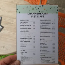 Drankenkaart van fietscafé met categorieën voor frisdranken, fruitsoppen, waters, warme dranken, bieren en wijnen met prijzen