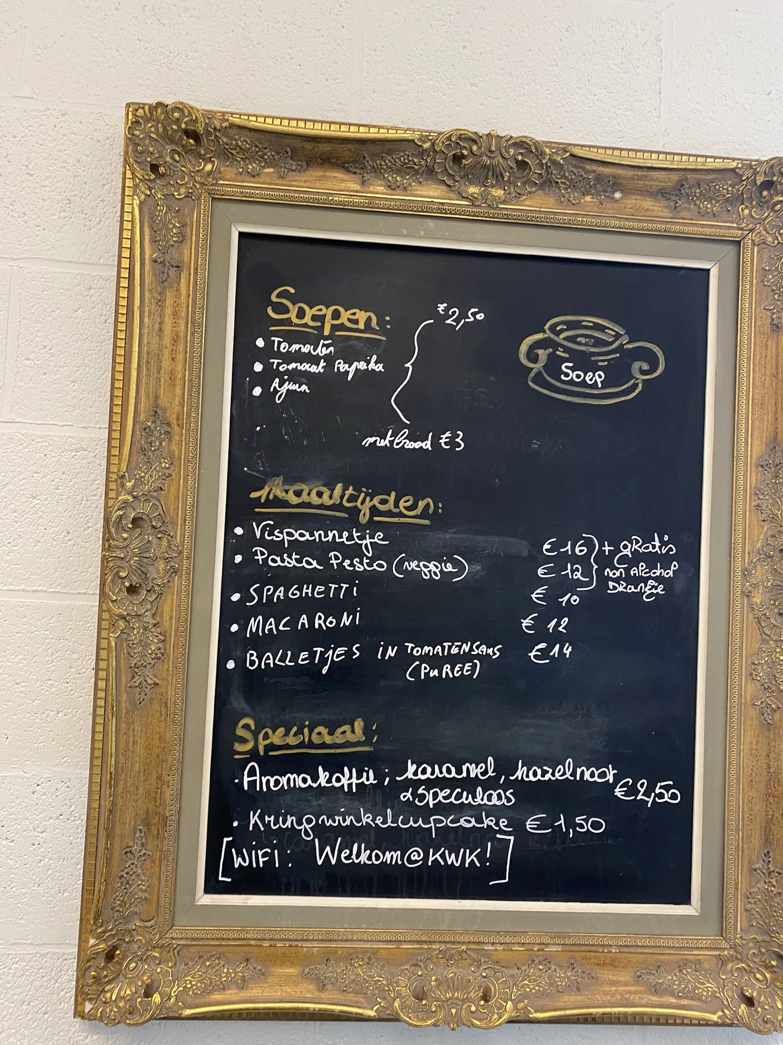 Menukaart op schoolbord met gerechten en prijzen in euro's, inclusief soepen, hoofdgerechten en specials