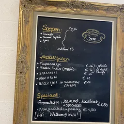 Menukaart op schoolbord met gerechten en prijzen in euro's, inclusief soepen, hoofdgerechten en specials