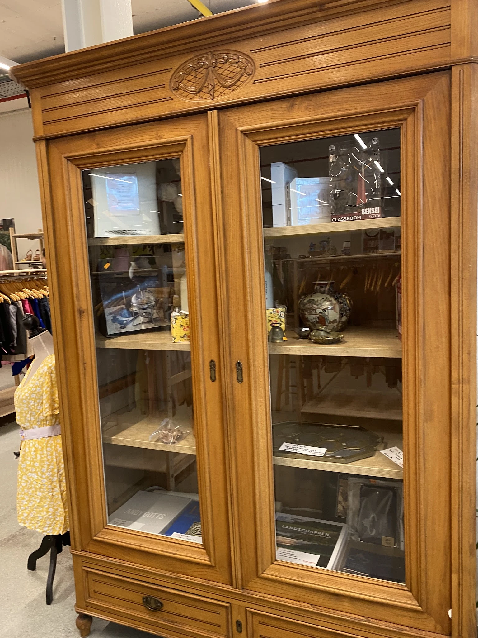 Glazen displaykasten met houten frames, gevuld met decoratieve voorwerpen en vazen