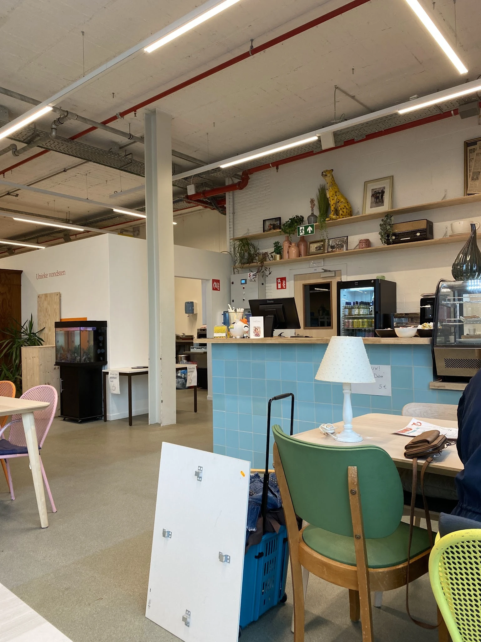 Koffiehoek met blauwe balie, koffiemachines, espressoapparaat en dienblad met kopje in kringloopwinkel