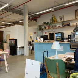 Koffiehoek met blauwe balie, koffiemachines, espressoapparaat en dienblad met kopje in kringloopwinkel