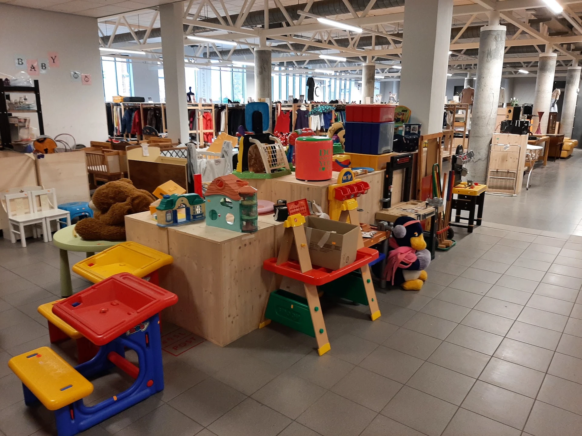 Ruim magazijn met speelgoed, houten meubels en diverse tweedehands artikelen netjes uitgestald