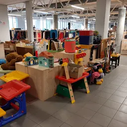 Ruim magazijn met speelgoed, houten meubels en diverse tweedehands artikelen netjes uitgestald