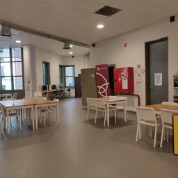 Ruime winkelruimte met tafels, stoelen, kasten en stellingen met diverse spullen