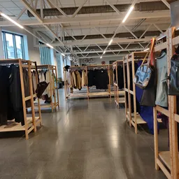 Winkelvloer met houten rekken vol tweedehands kleding langs beide zijden