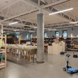 Ruim winkelinterieur met houten meubels, rekken met spullen en speelgoed op de vloer