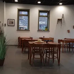 Koffiehoek met houten tafels en stoelen in de kringloopwinkel