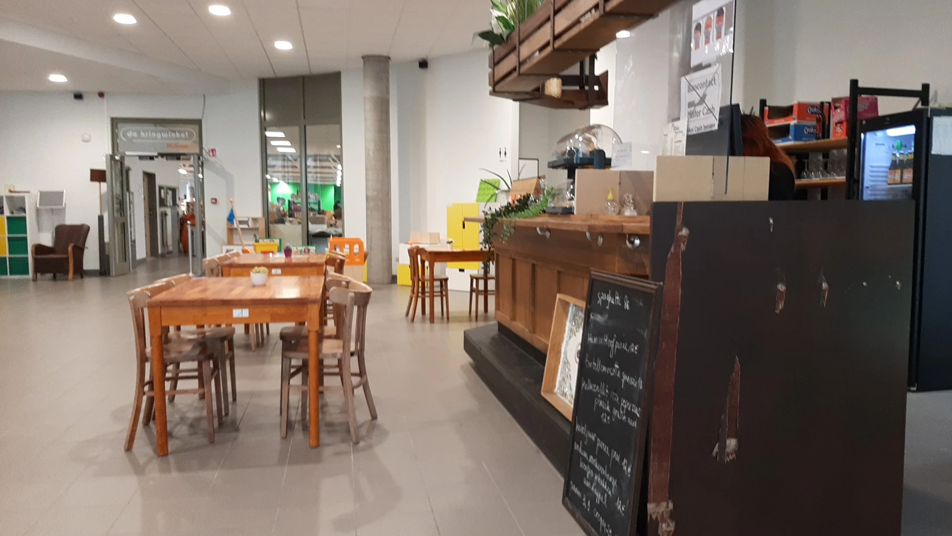 Winkelvloer met houten tafels, stoelen en diverse meubels en spullen in een kringloopwinkel