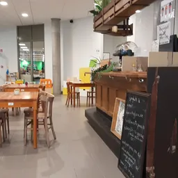Winkelvloer met houten tafels, stoelen en diverse meubels en spullen in een kringloopwinkel