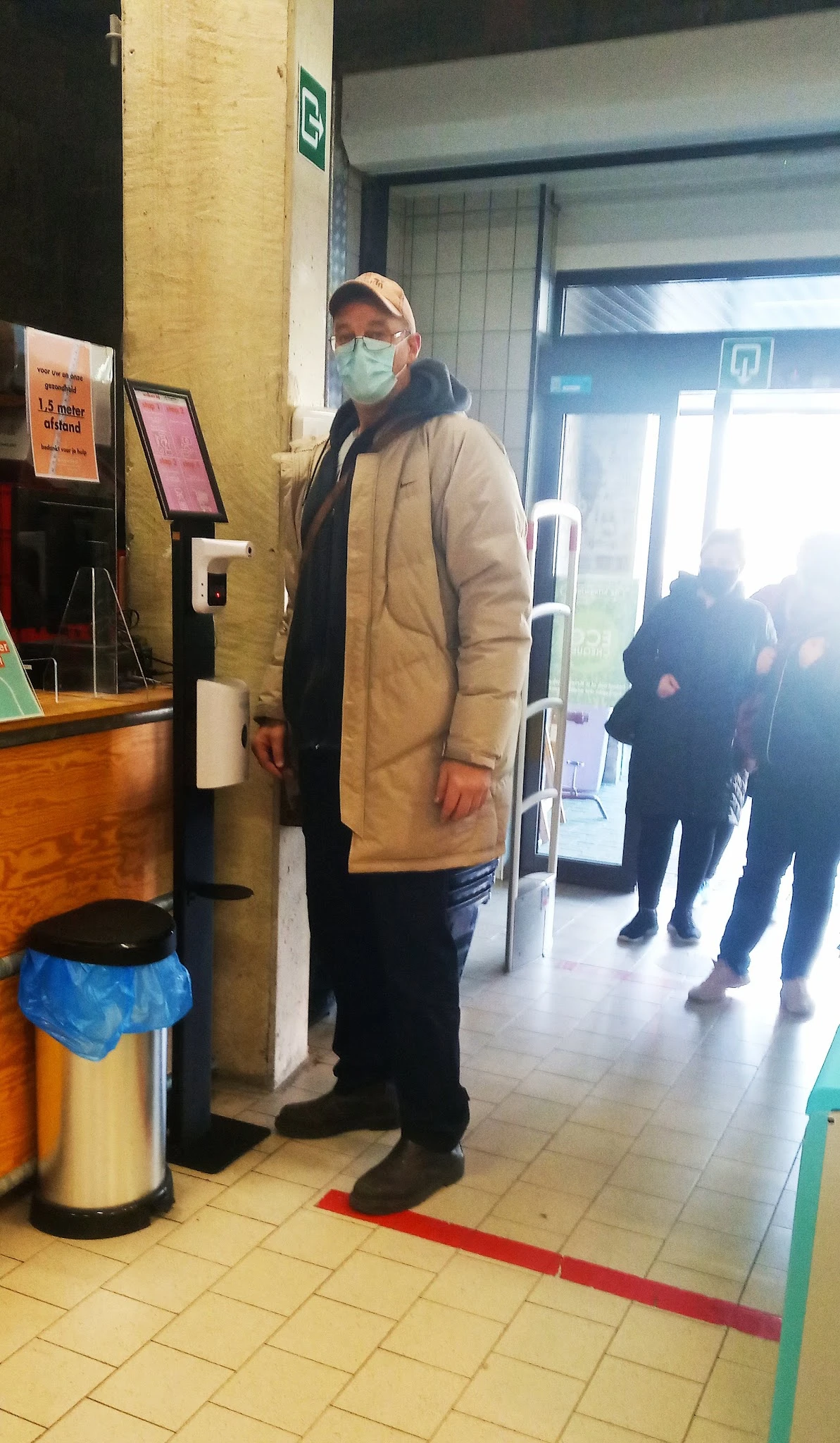 Winkelinterieur met klant bij ingang, zicht op deur en gedeelte van winkelvloer