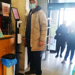 Winkelinterieur met klant bij ingang, zicht op deur en gedeelte van winkelvloer