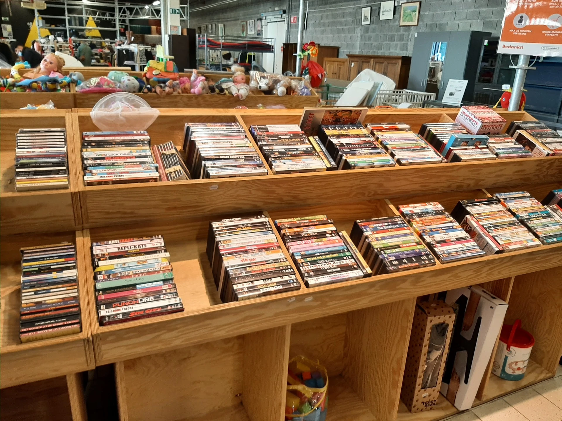 Houten stellingen vol met cd's en dvd's, netjes uitgestald in dozen