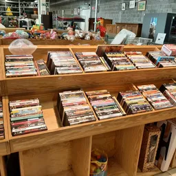 Houten stellingen vol met cd's en dvd's, netjes uitgestald in dozen
