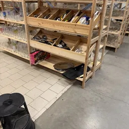 Houten stellingkast met verschillende huishoudelijke artikelen en kookgerei op planken