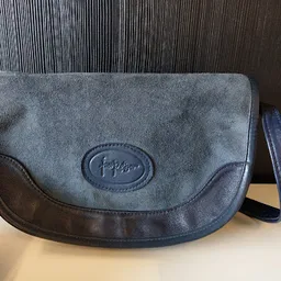 Grijze schoudertas met donkerblauwe leren accenten en verstelbare schouderriem