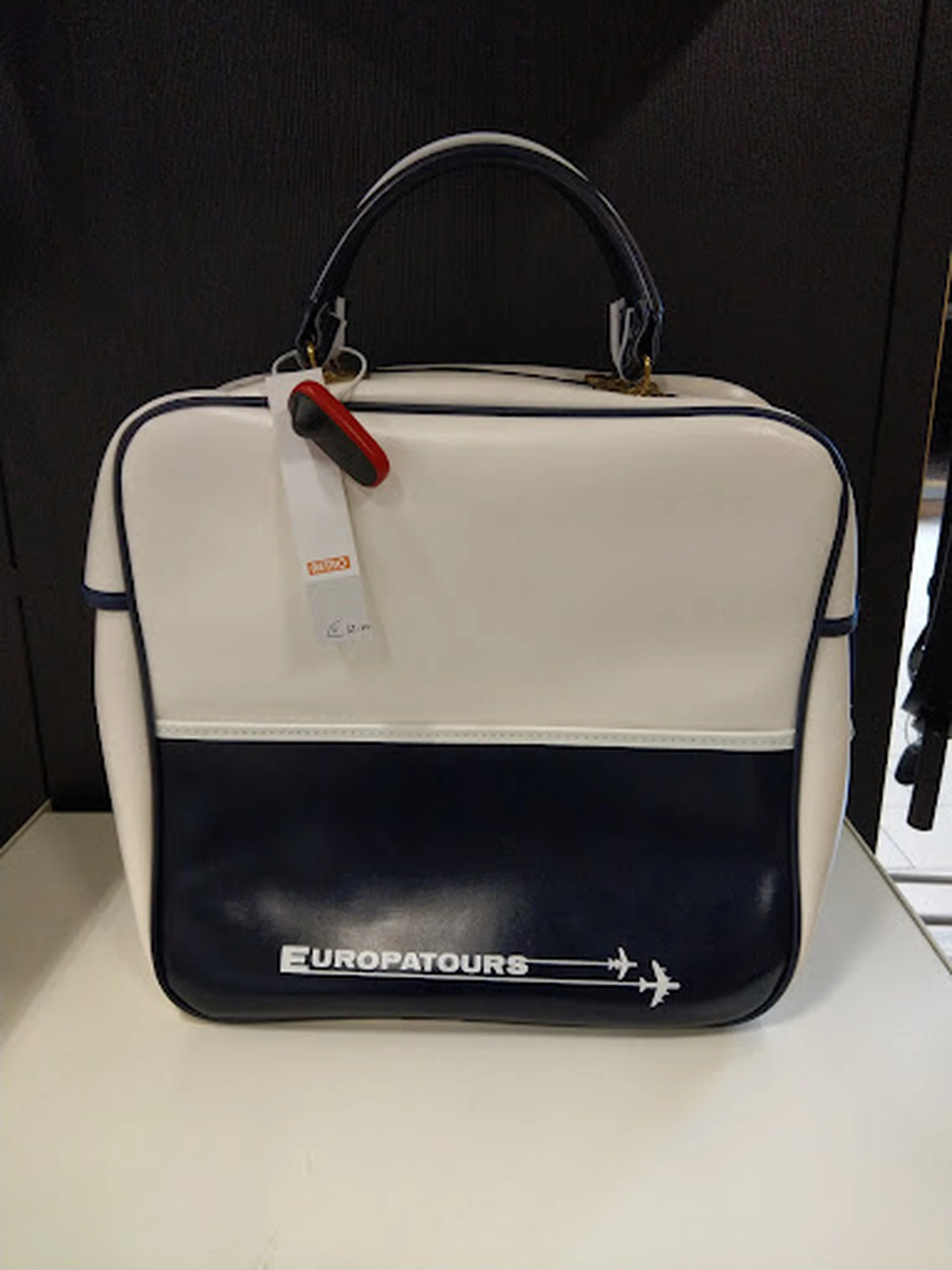 Vintage reiskoffer in crème en donkerblauw met Europatours-logo en rood etiket
