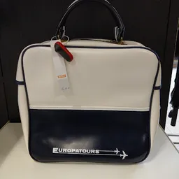 Vintage reiskoffer in crème en donkerblauw met Europatours-logo en rood etiket