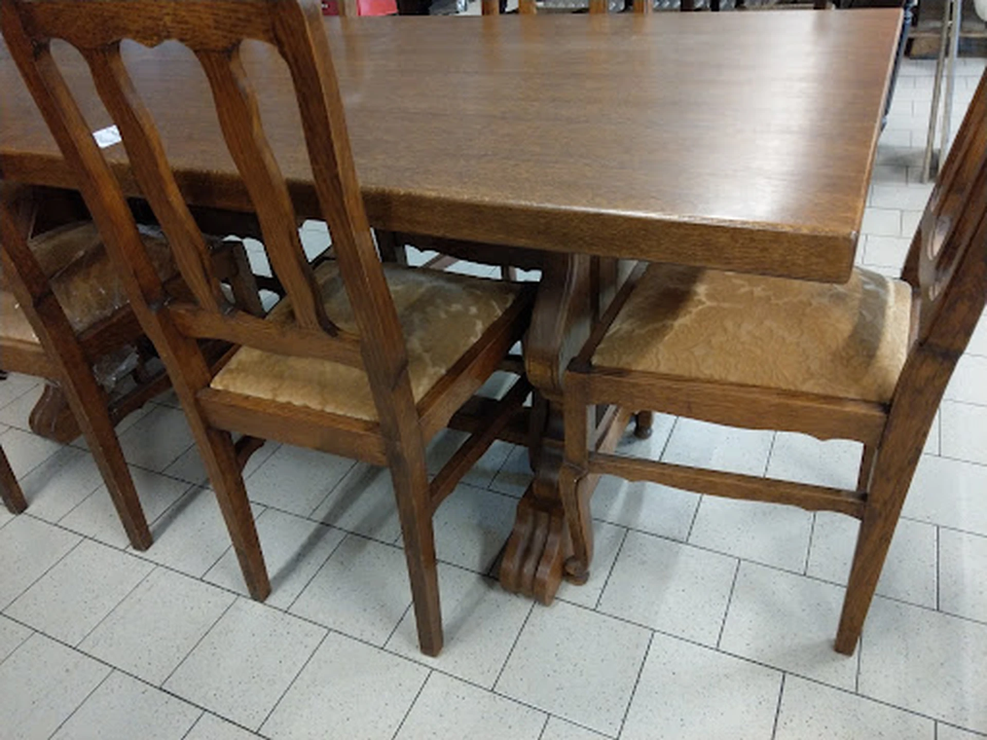 Houten eettafel met vier stoelen, gemaakt van donker hout met rieten zittingen