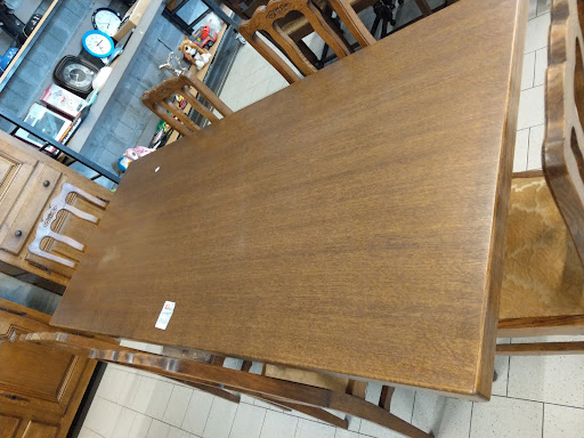 Houten eettafel met bruine tafelblad en houten poten in kringloopwinkel