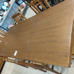 Houten eettafel met bruine tafelblad en houten poten in kringloopwinkel