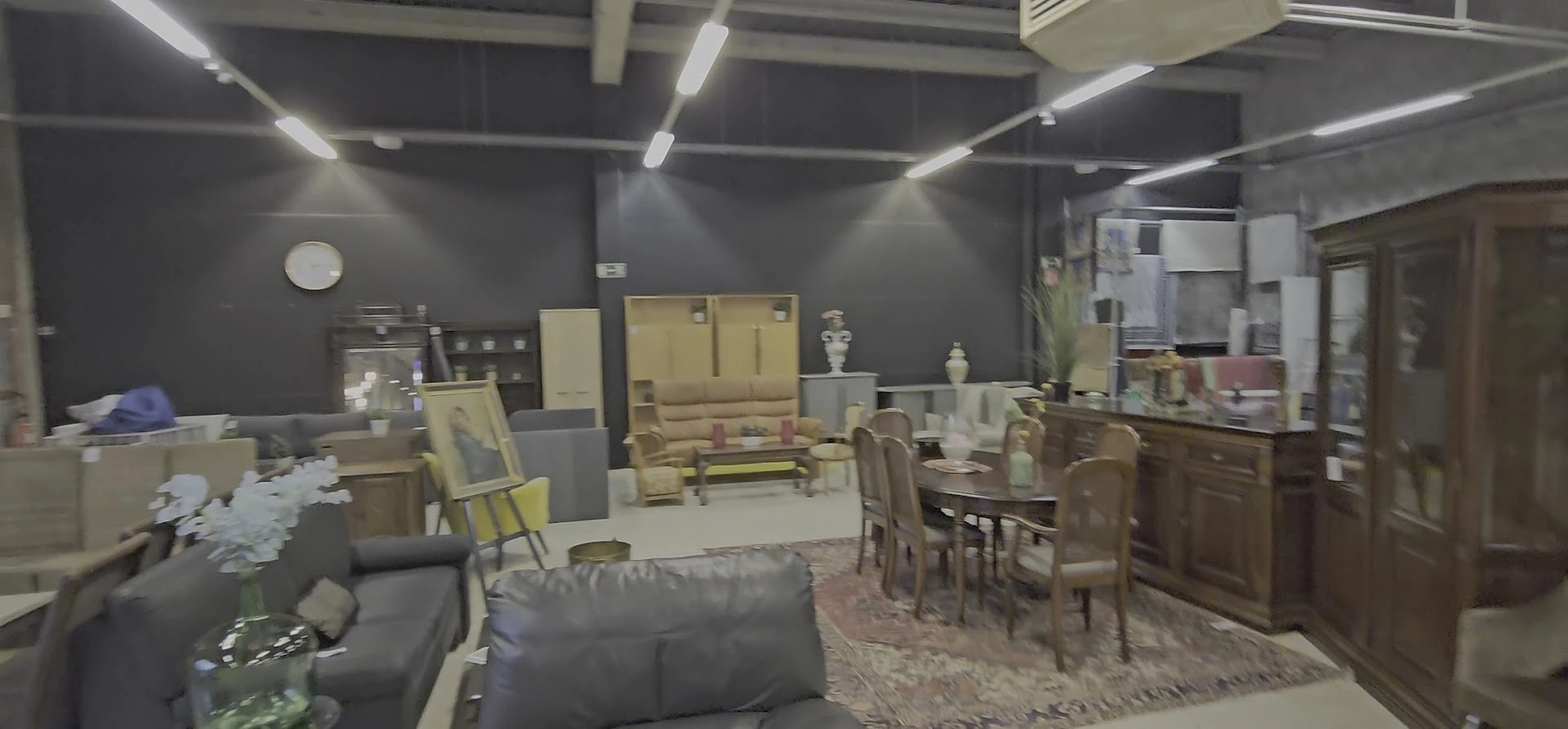 Winkelvloer met meubels, stoelen, tafels en decoratiestukken uitgestald onder LED-verlichting