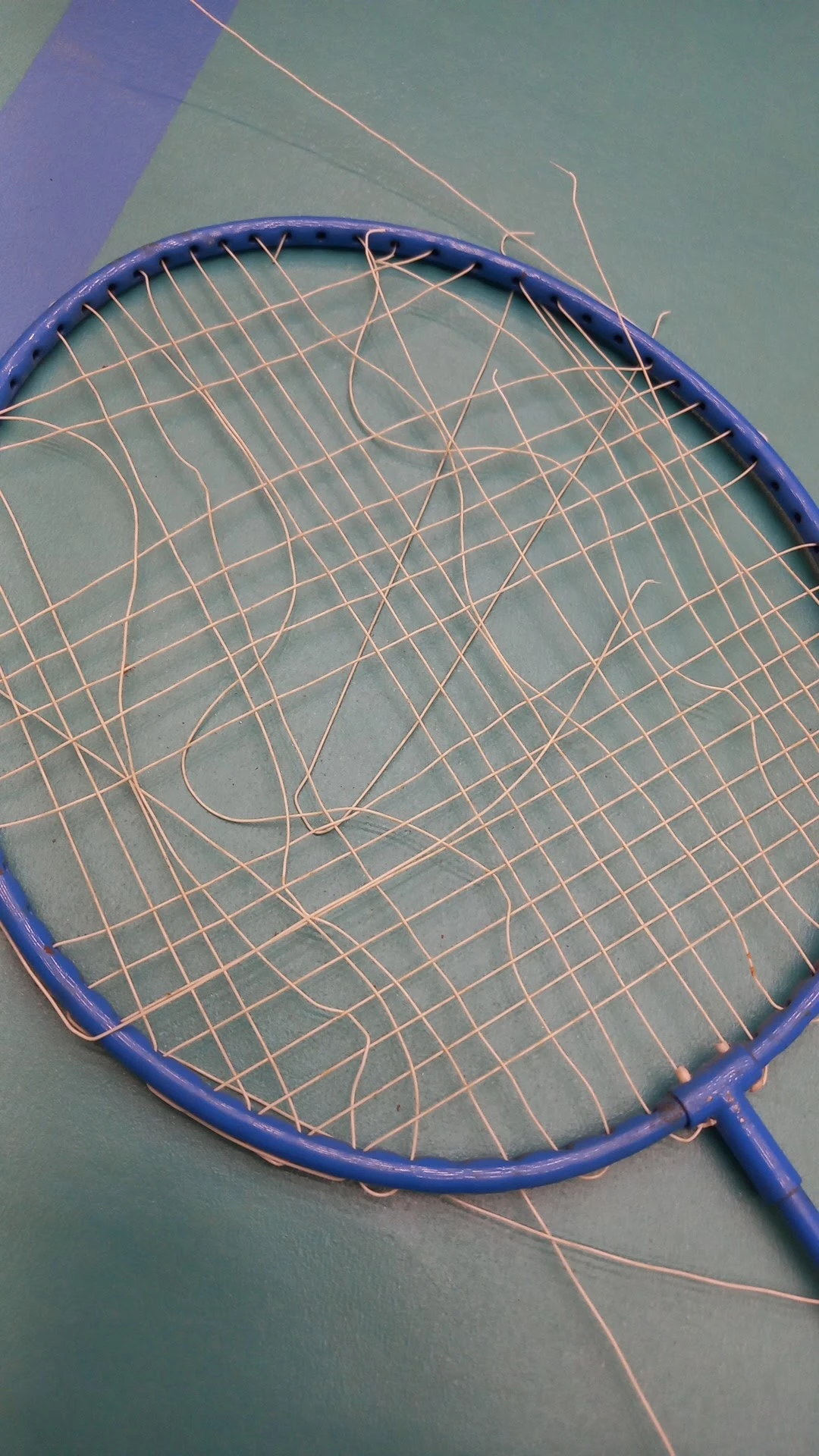 Close-up van een badmintonracket met beschadigde bespanning