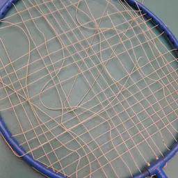 Close-up van een badmintonracket met beschadigde bespanning