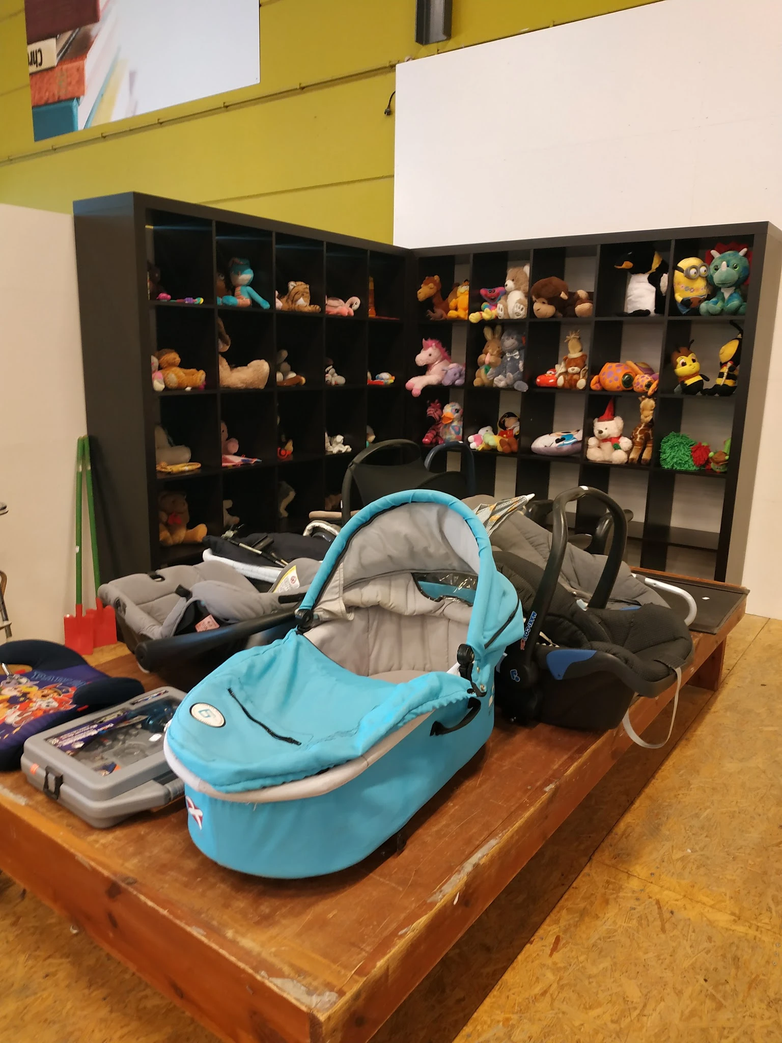 Kinderwagens en speelgoed uitgestald in een kringloopwinkel