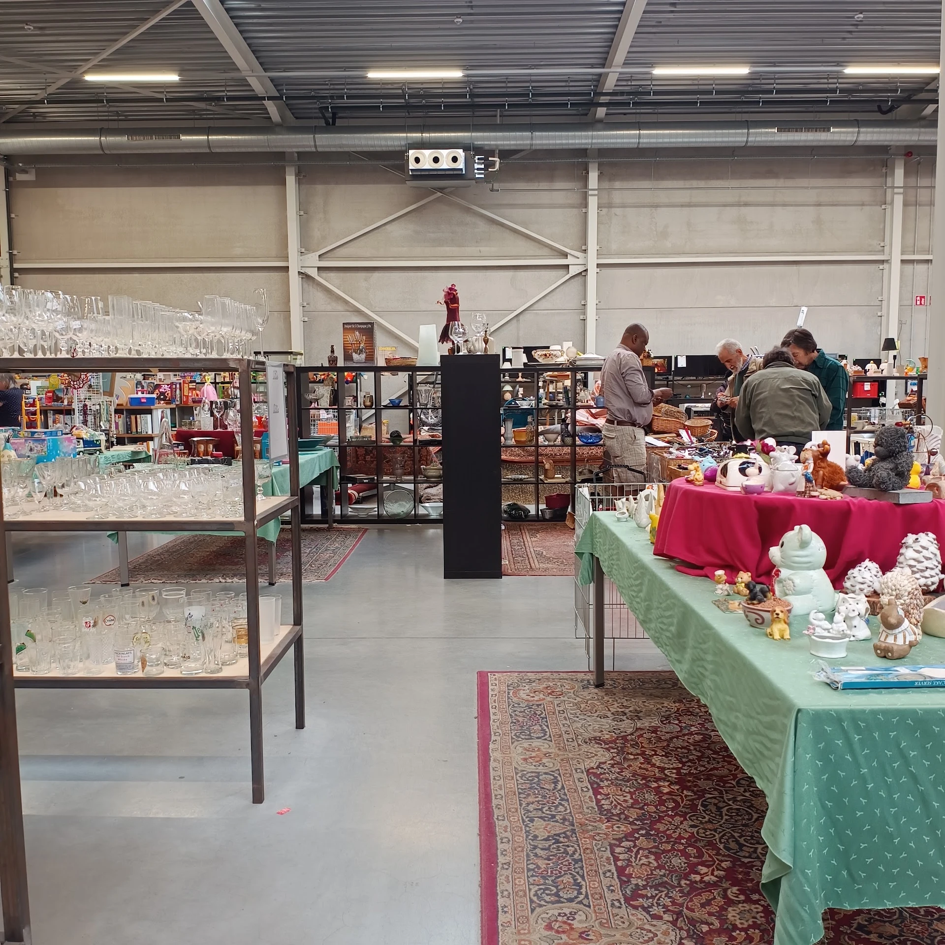 Winkelvloer met display tafels en stellingen vol tweedehandsartikelen in een kringloopwinkel