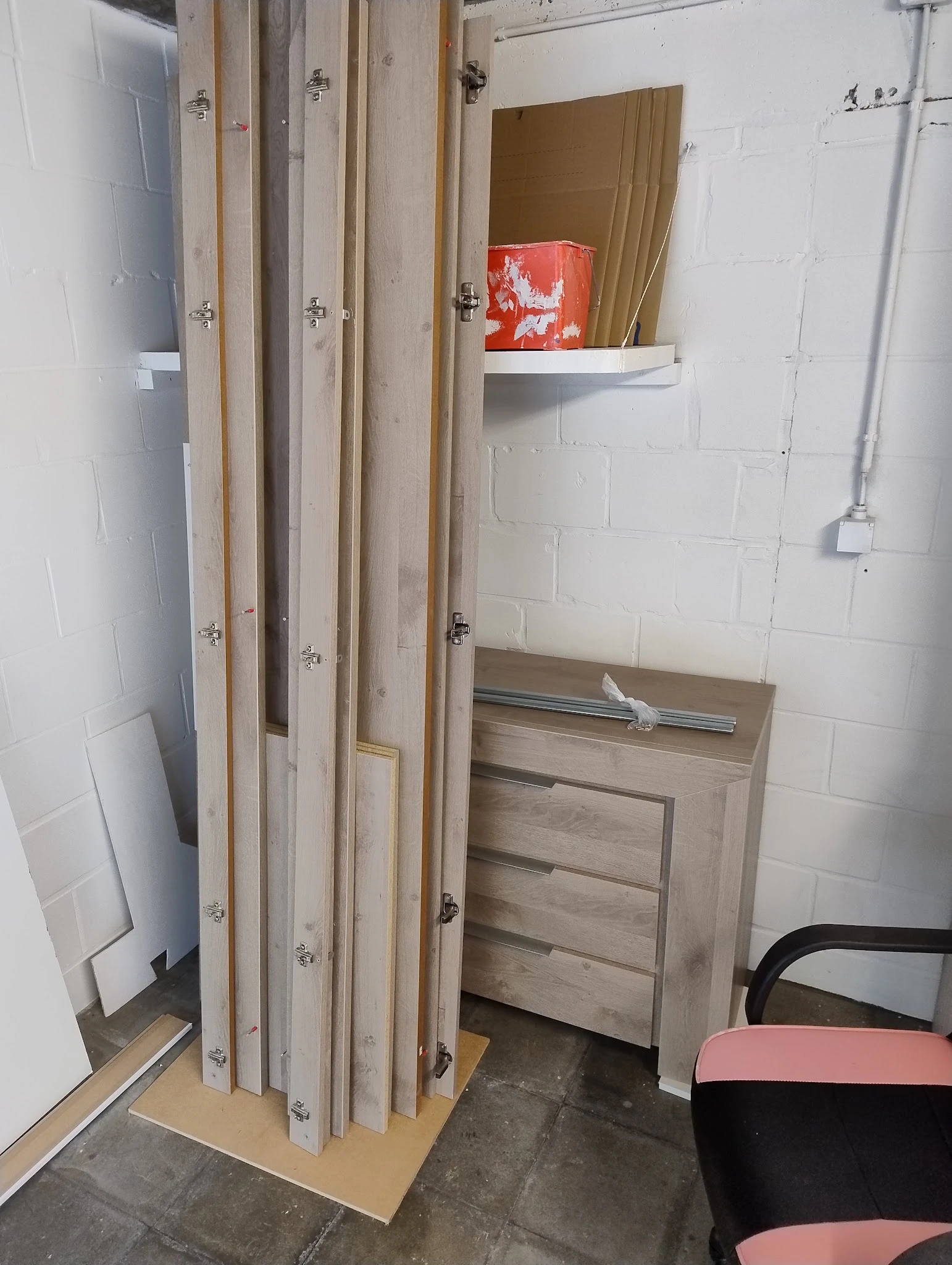 Houten meubel met laden en spiegeldeuren tegen witte bakstenen muur