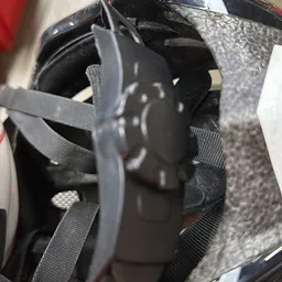Close-up van een zwarte helm met verstelbare riemen en bevestigingsmechanieken